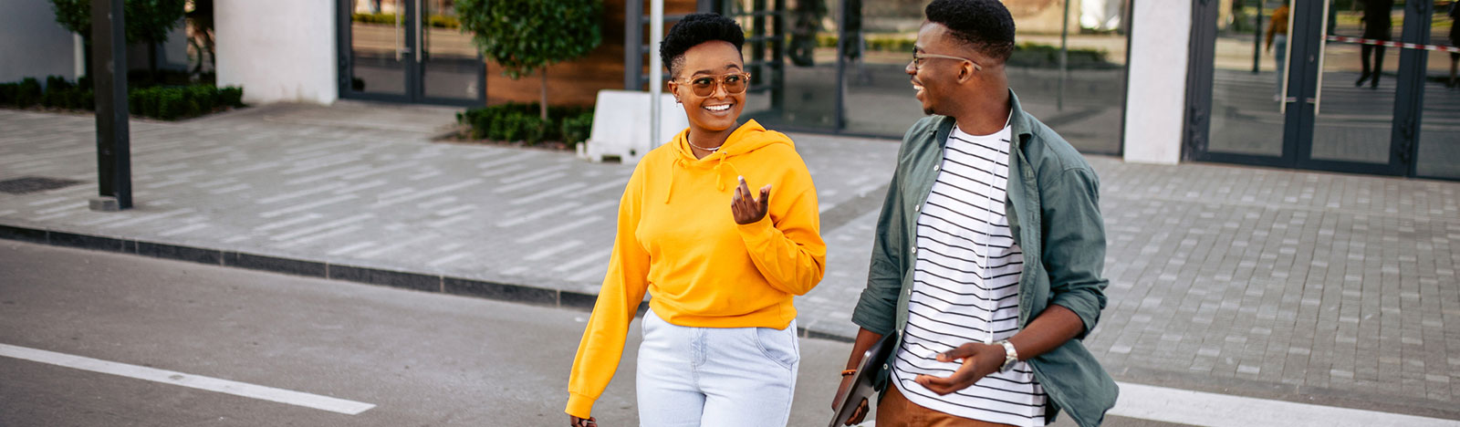 Two young adults crossing the street