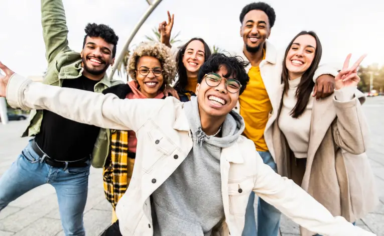 a group of diverse young adults smiling outside