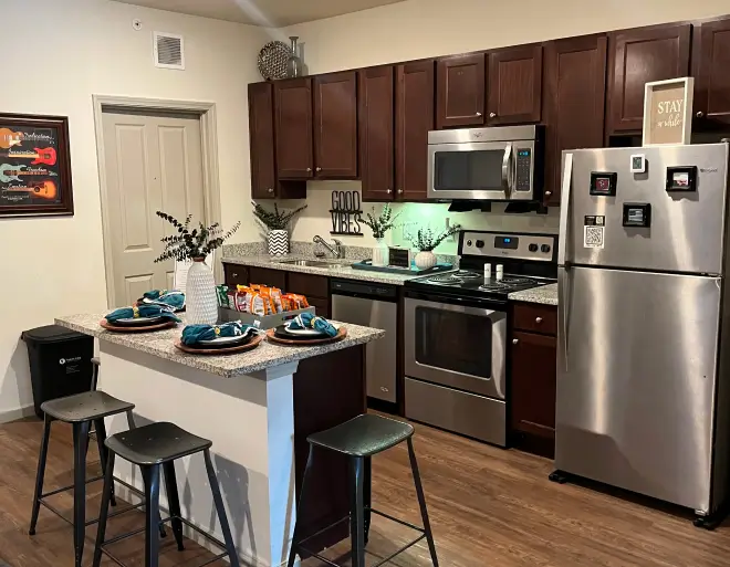 furnished student apartment kitchen with stainless steel appliances