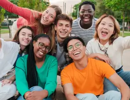 a group of diverse young adults smiling outside